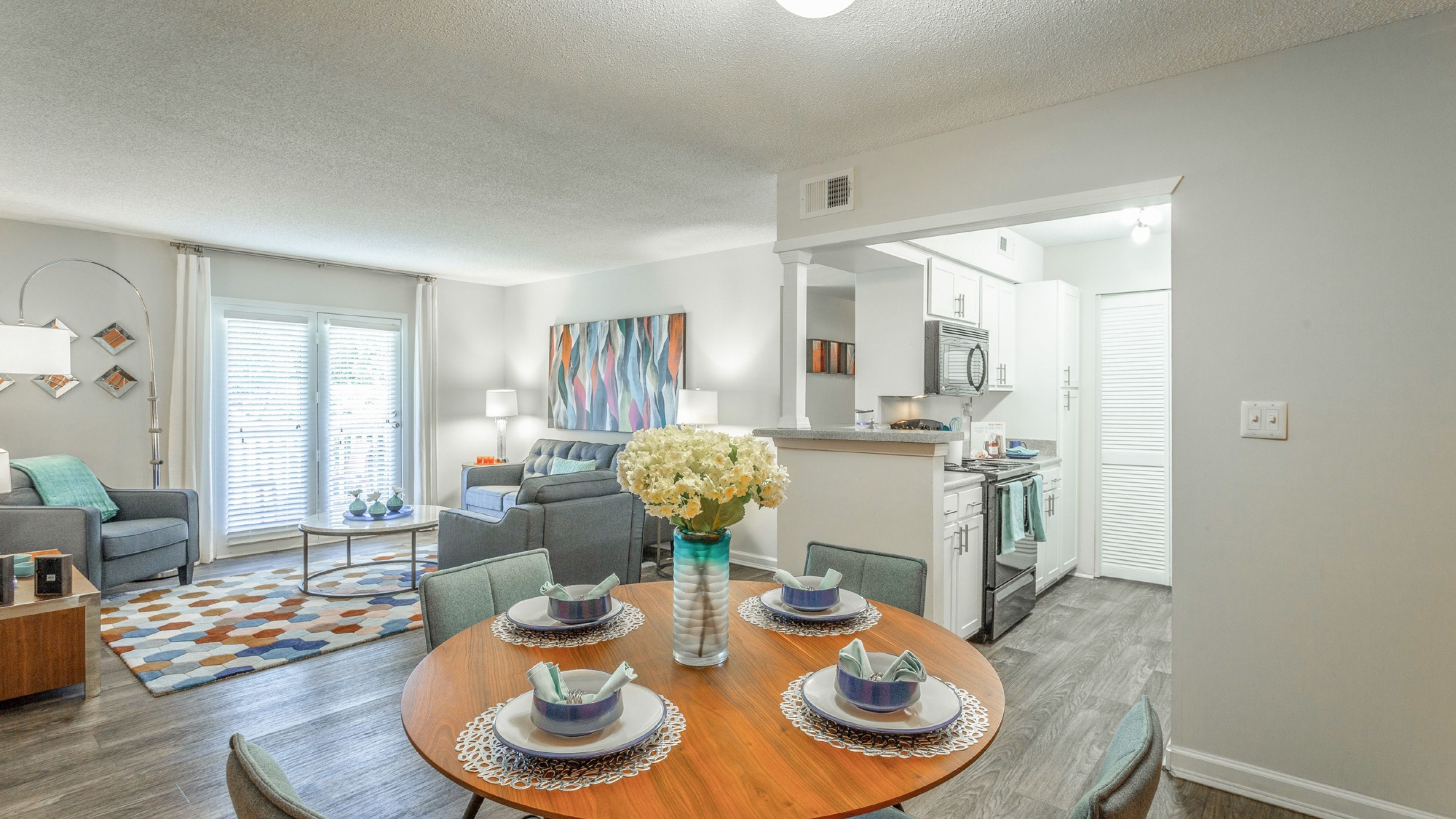 Hawthorne at Lily Flagg apartment living space and kitchen with small dining table, and stainless steel appliances